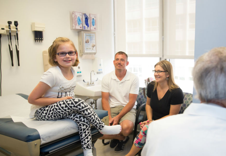 child sitting on table at doctors office