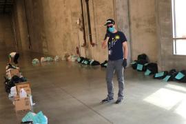 A man wearing a surgical mask with bags and boxes of supplies
