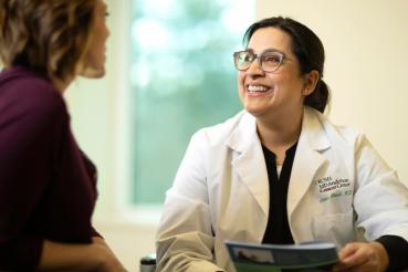 Dr. Amina Ahmed smiles while talking to another person.